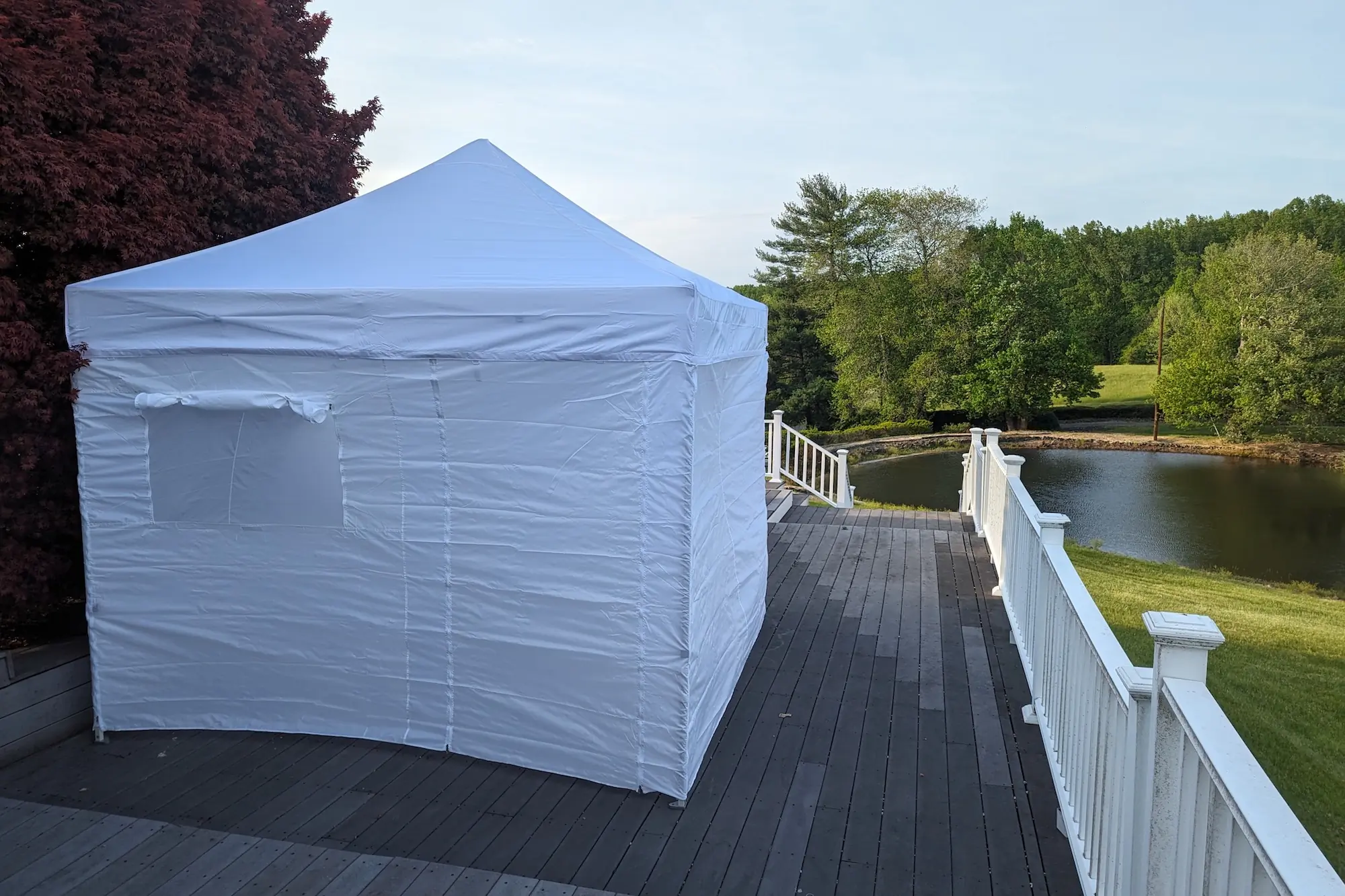 The Eurmax USA 10 x 10 Pop-up Canopy set up on a porch with the optional walls installed