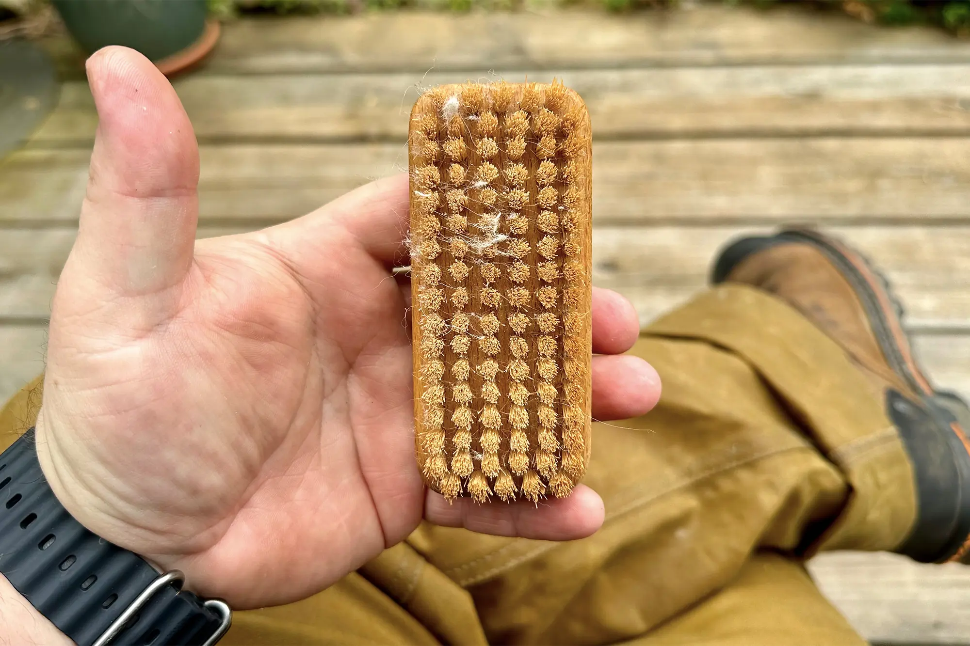 man holding filson single tin cloth pants gardner's nail brush