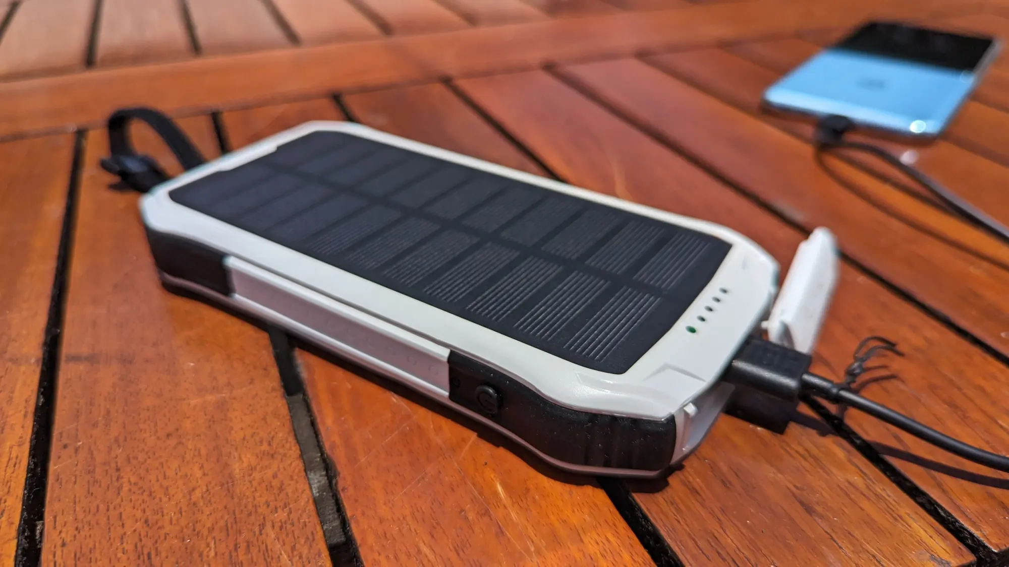 Gear Junkie - Best Portable Solar Charger - BoomPods Neutron Power Bank charging a phone.
