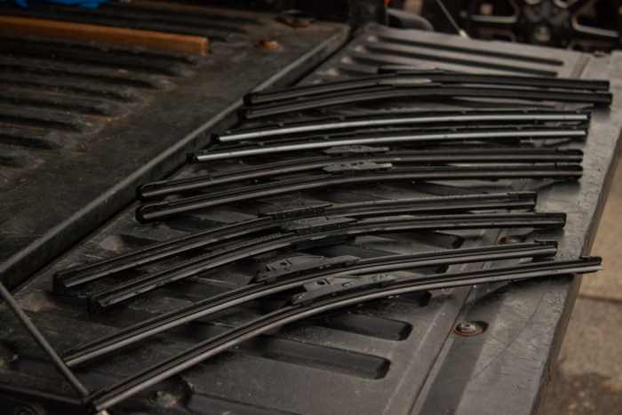 five sets of wiper blades laid on a truck tailgate ready to be tested