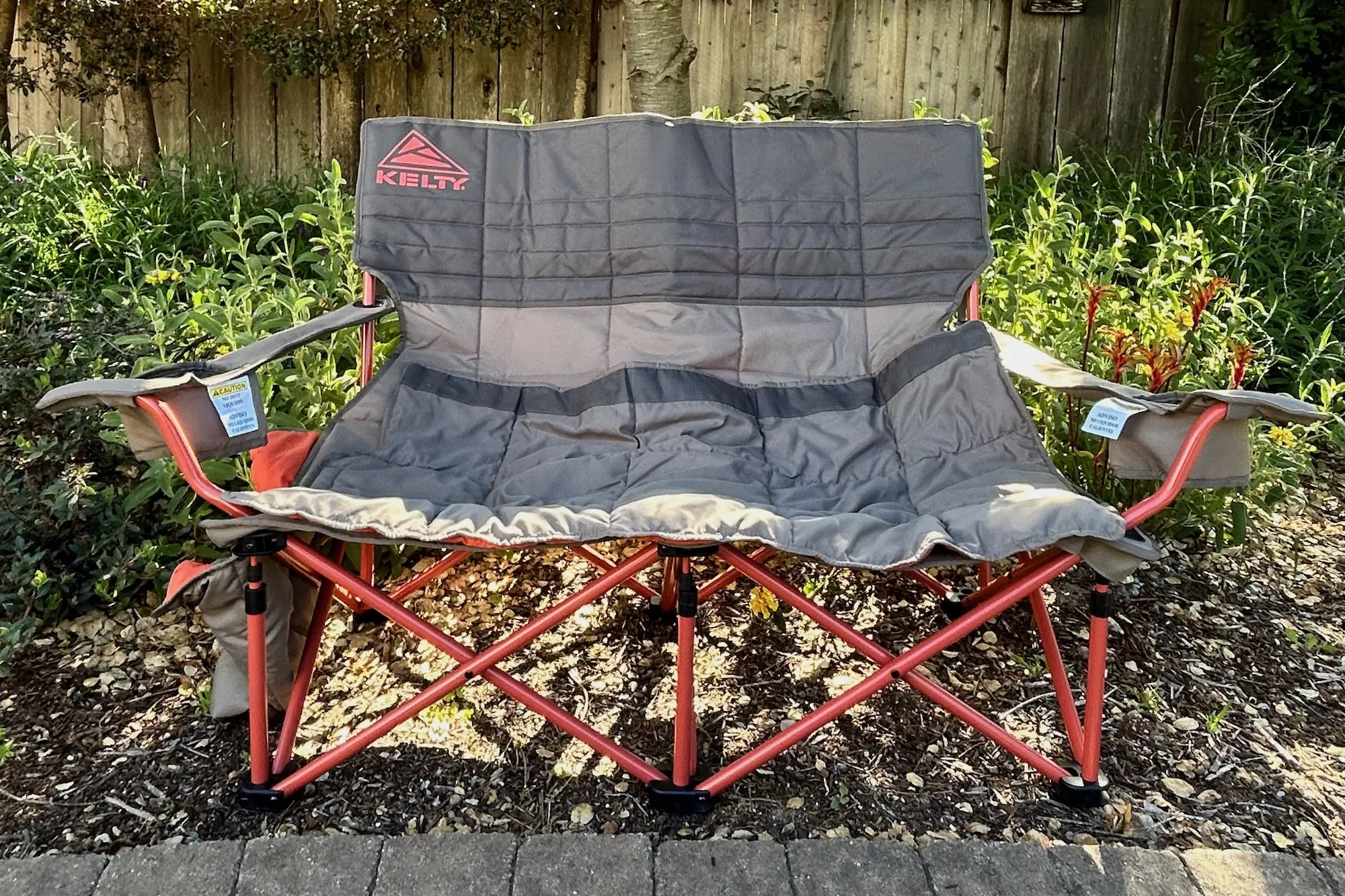 The Kelty Low Loveseat beach chair set up as extra seating in the backyard