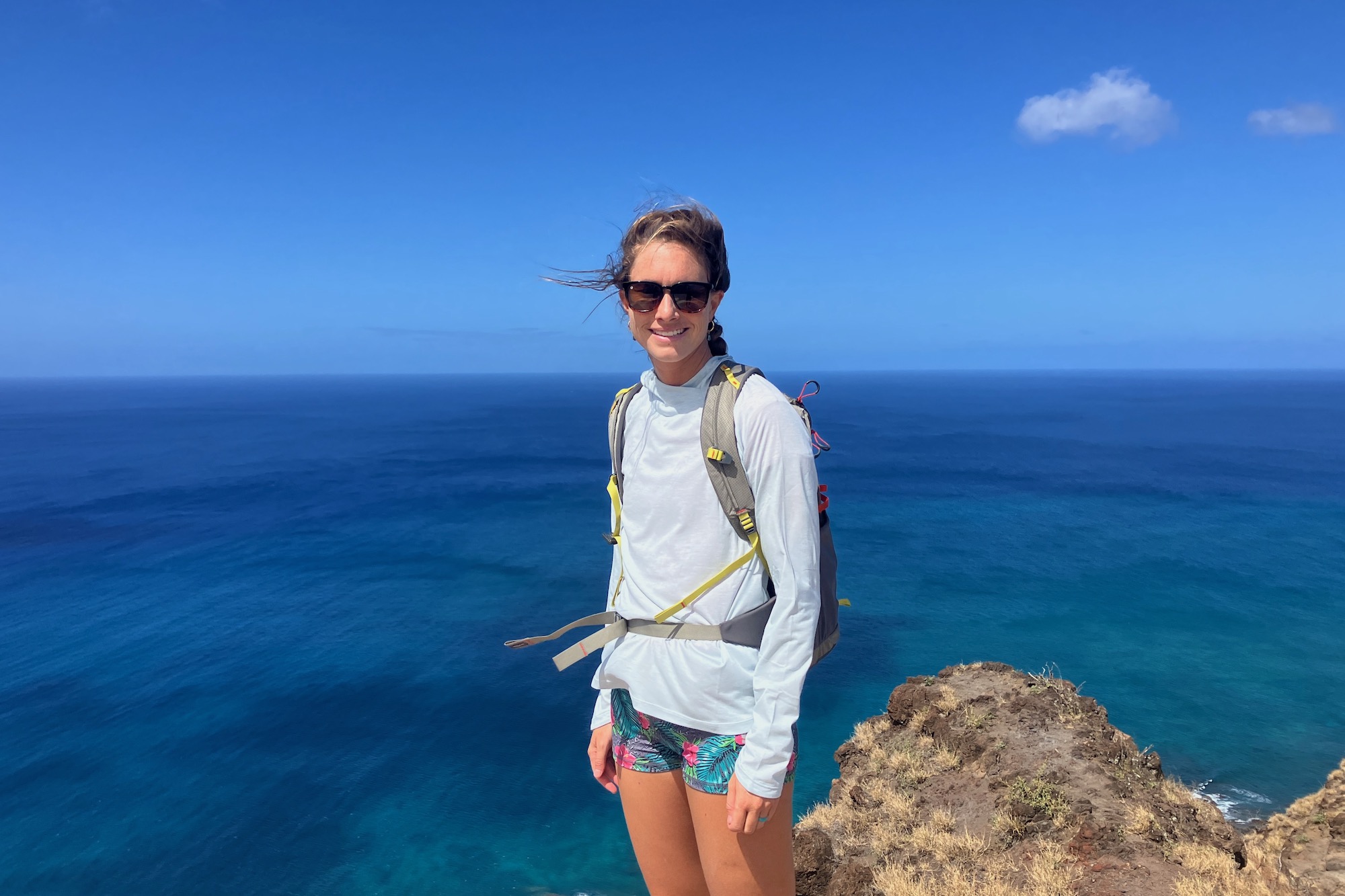 Standing on a mountaintop above the ocean in Hawaii wearing the Knockaround Premiums women's sunglasses