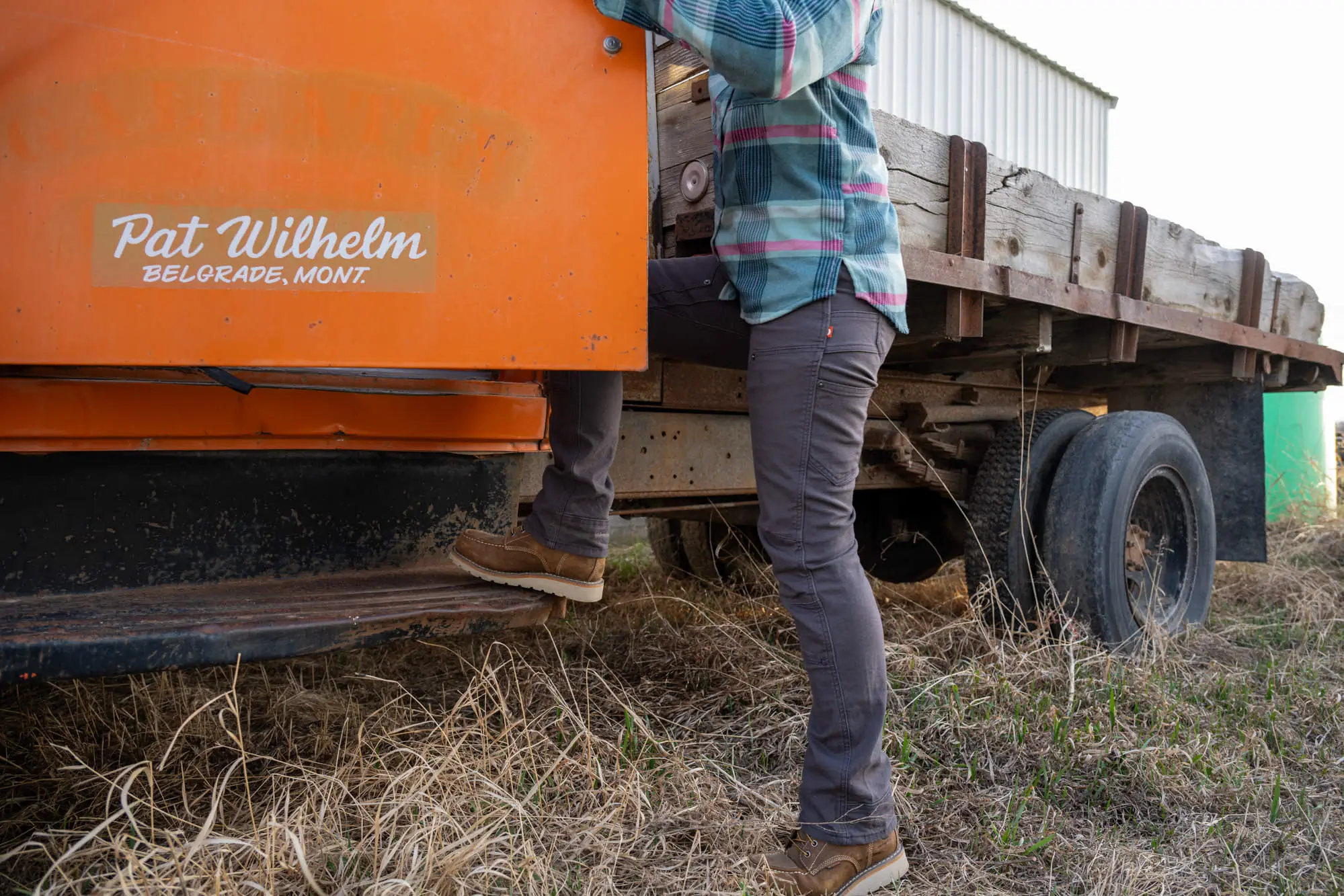 The author jumps into the cab of a farm truck in the Dovetail Britt Utility Pants