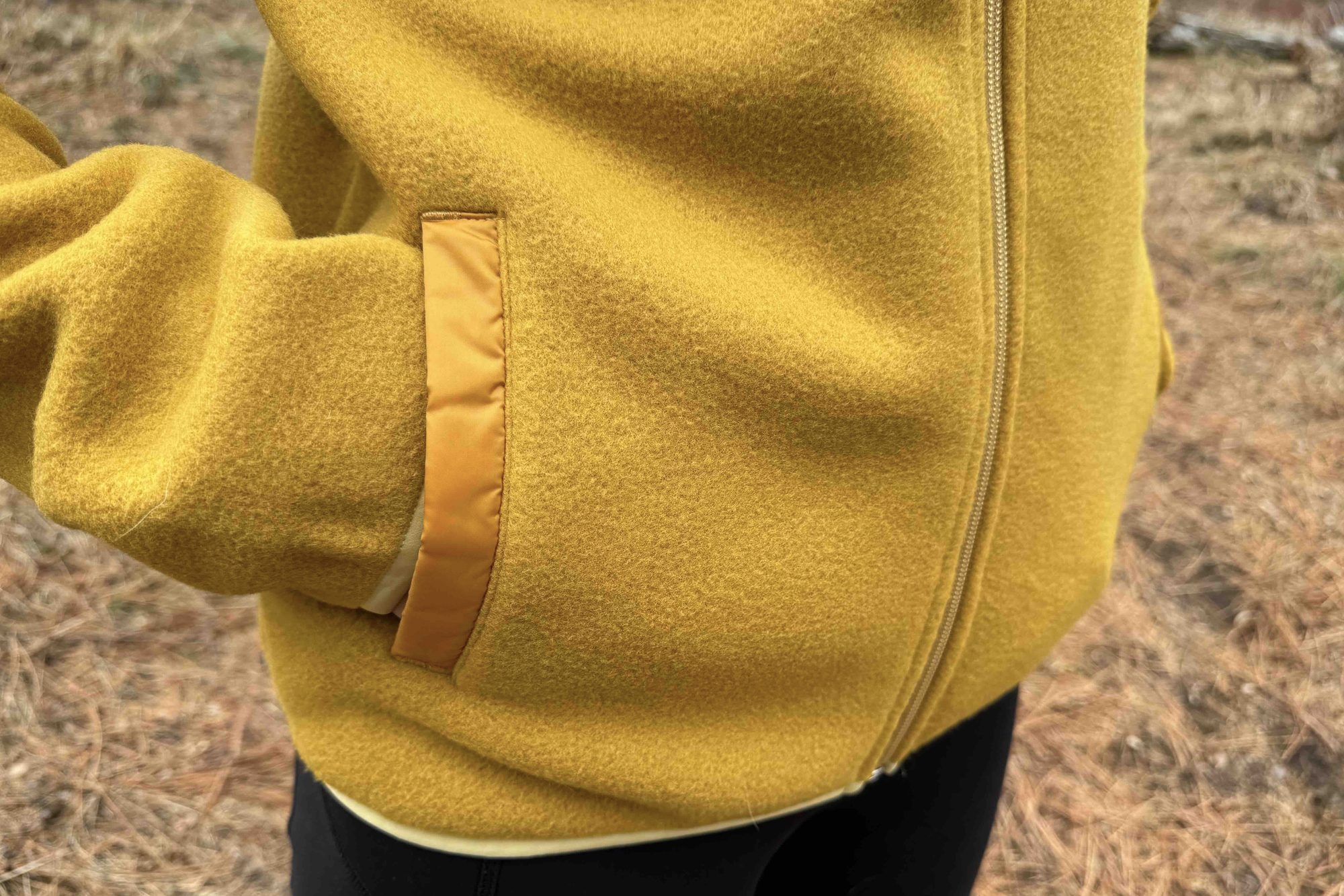 woman holding hands in cotopaxi teca fleece full-zip jacket pocket