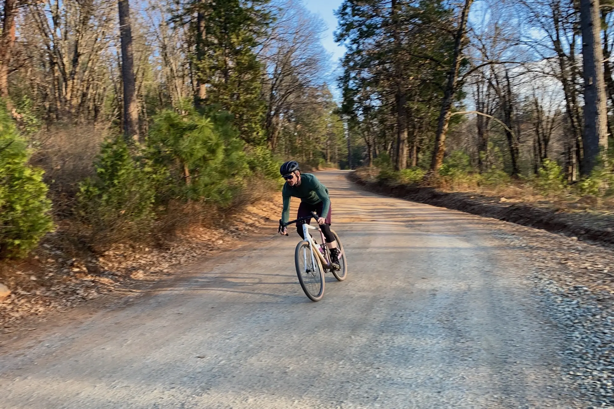 riding down a gravel road while testing the Ari Shafer gravel bike