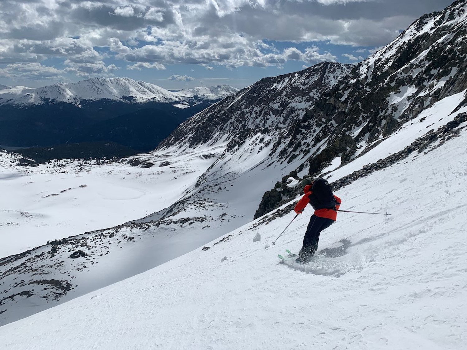 A man skiing down a snowy mountain slope