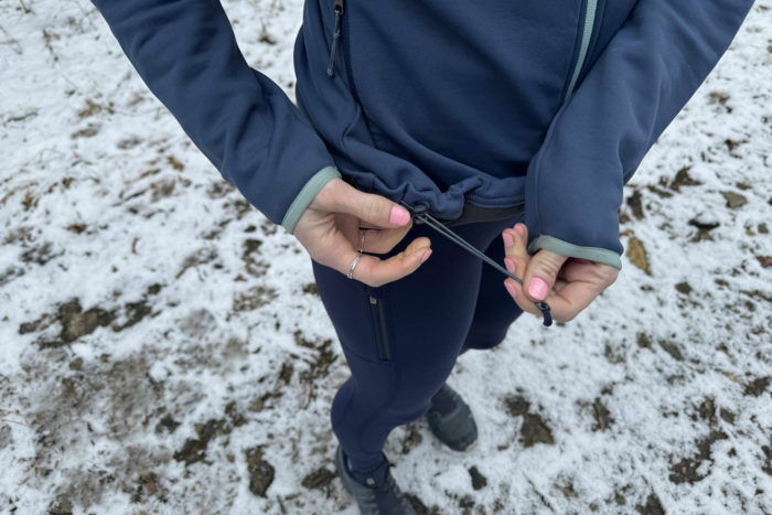 woman adjusting the rei co-op flash hyperstretch fleece jacket