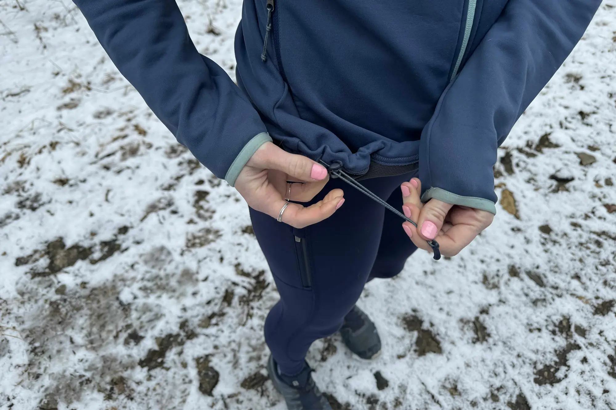 woman adjusting the rei co-op flash hyperstretch fleece jacket