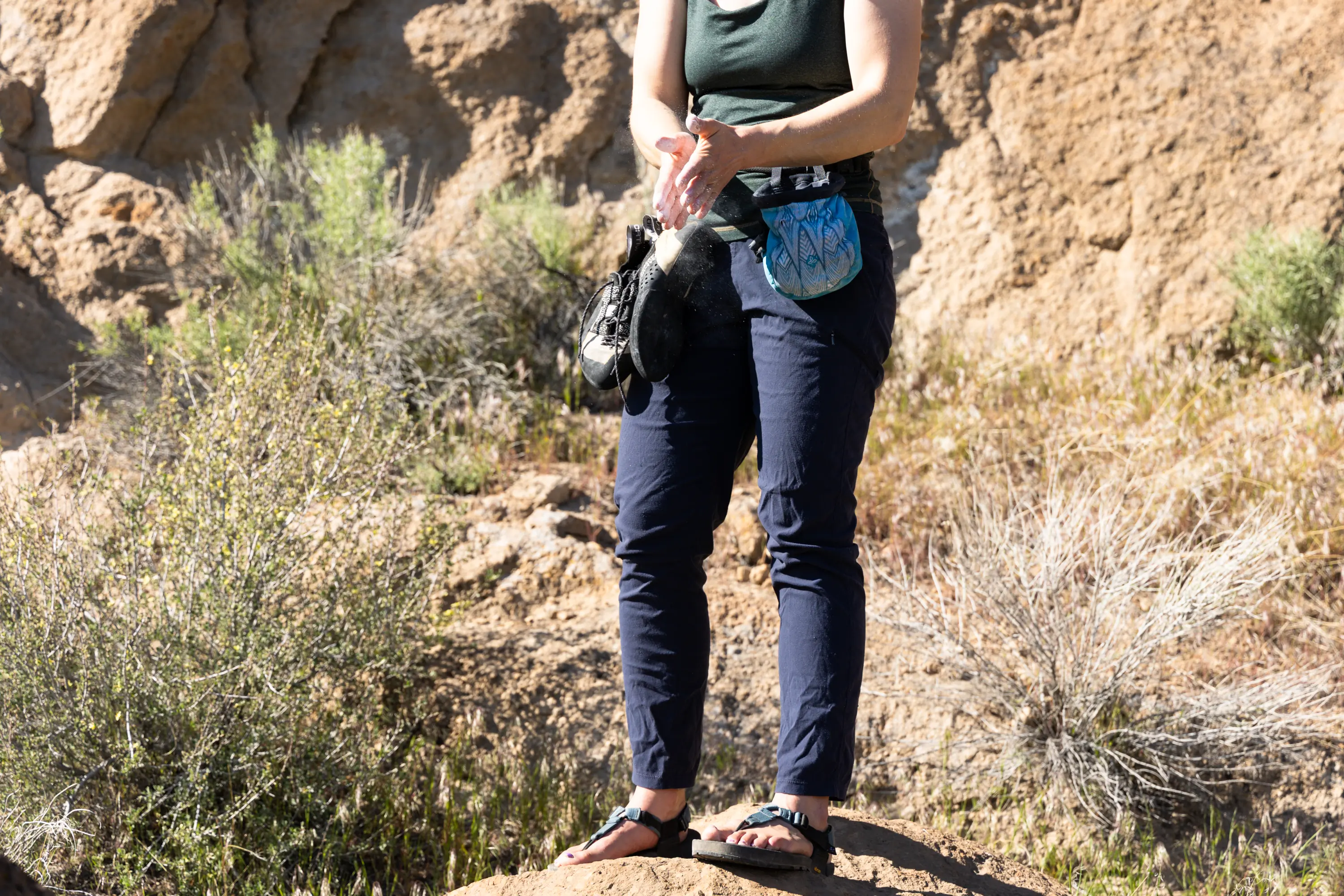 A climber chalks up while wearing a pair of travel pants