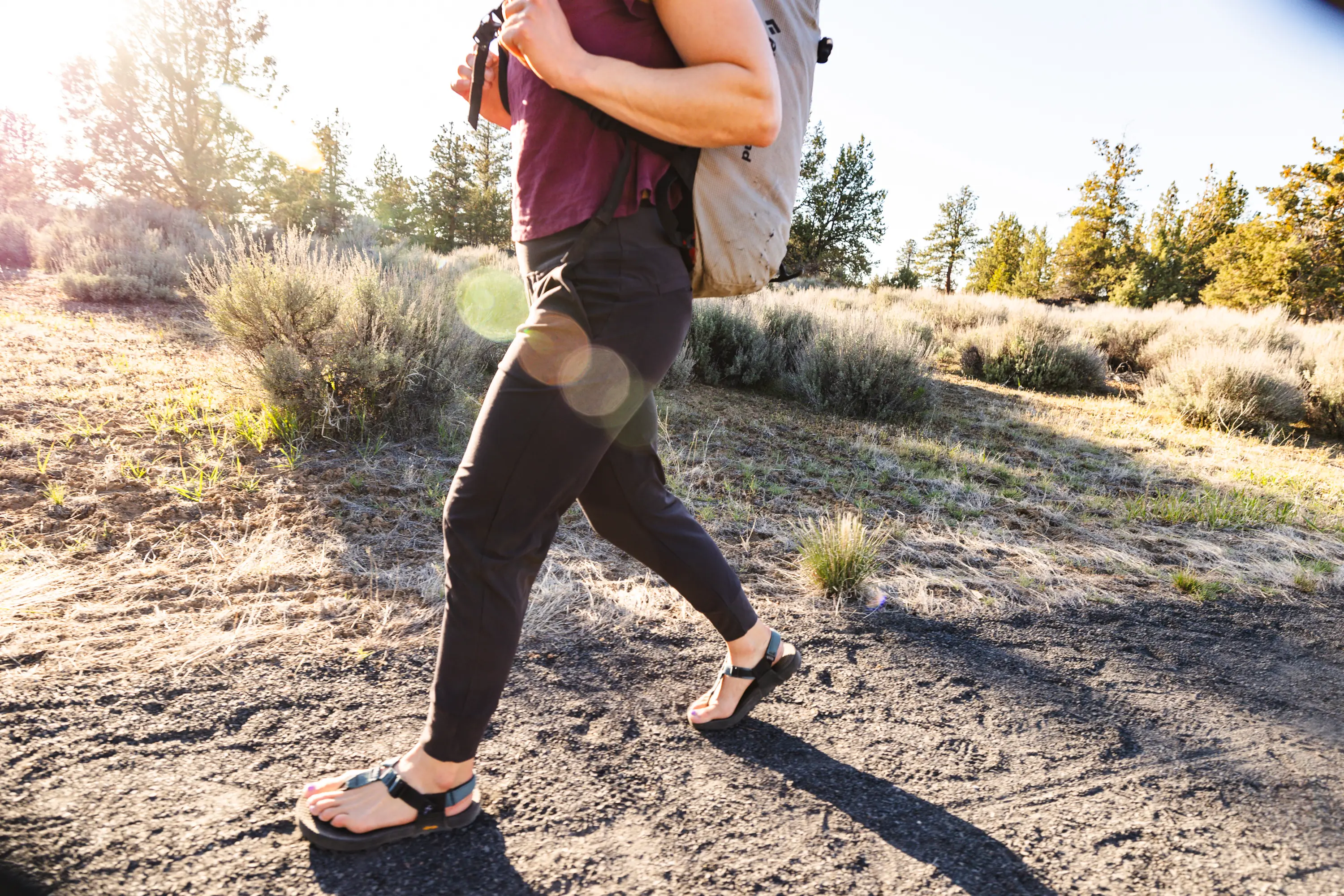A hiker walks on a path outside of Bend, Oregon wearing a pair of travel pants
