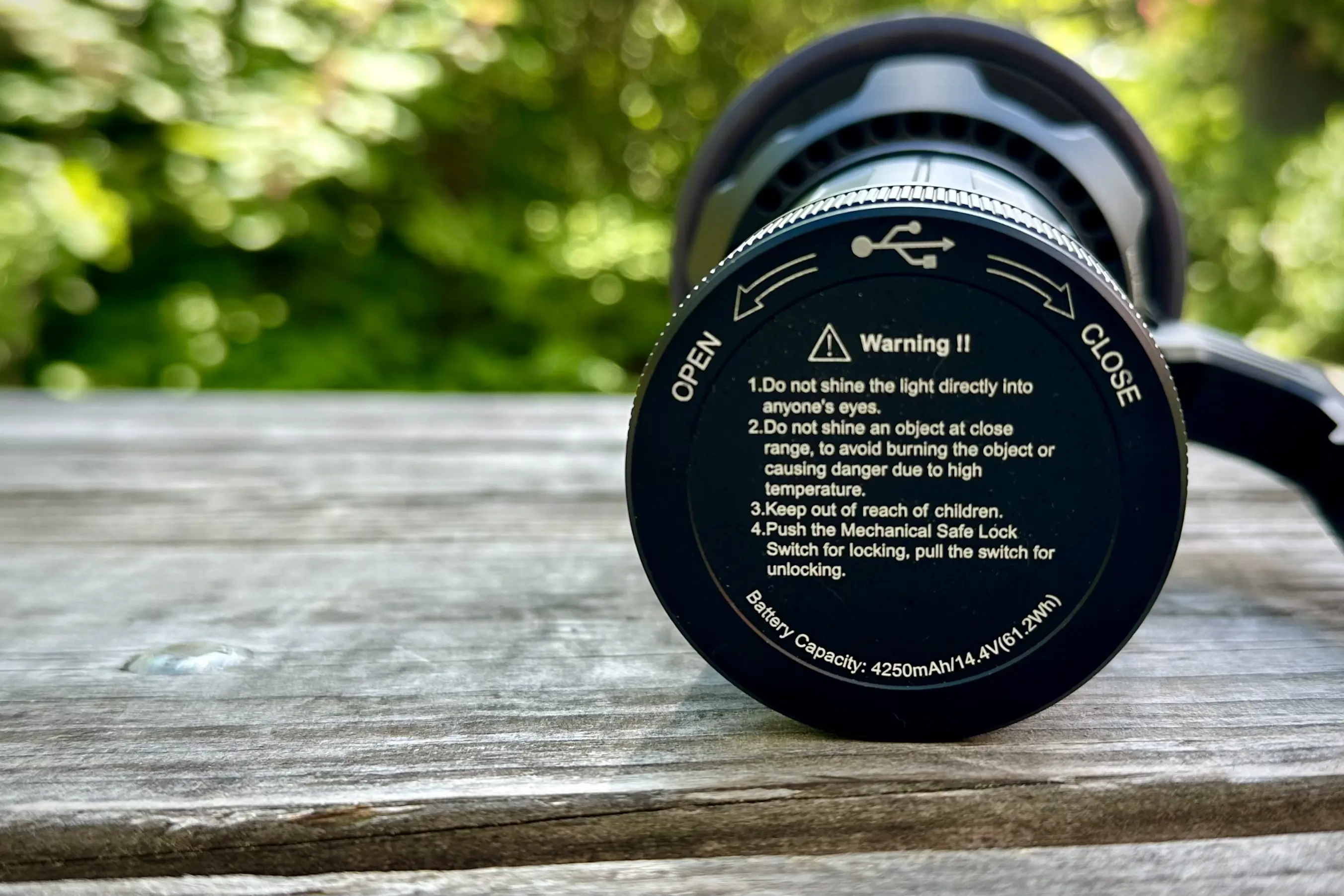 A photo displaying the warning sign about proper use on the flashlight's lens cover