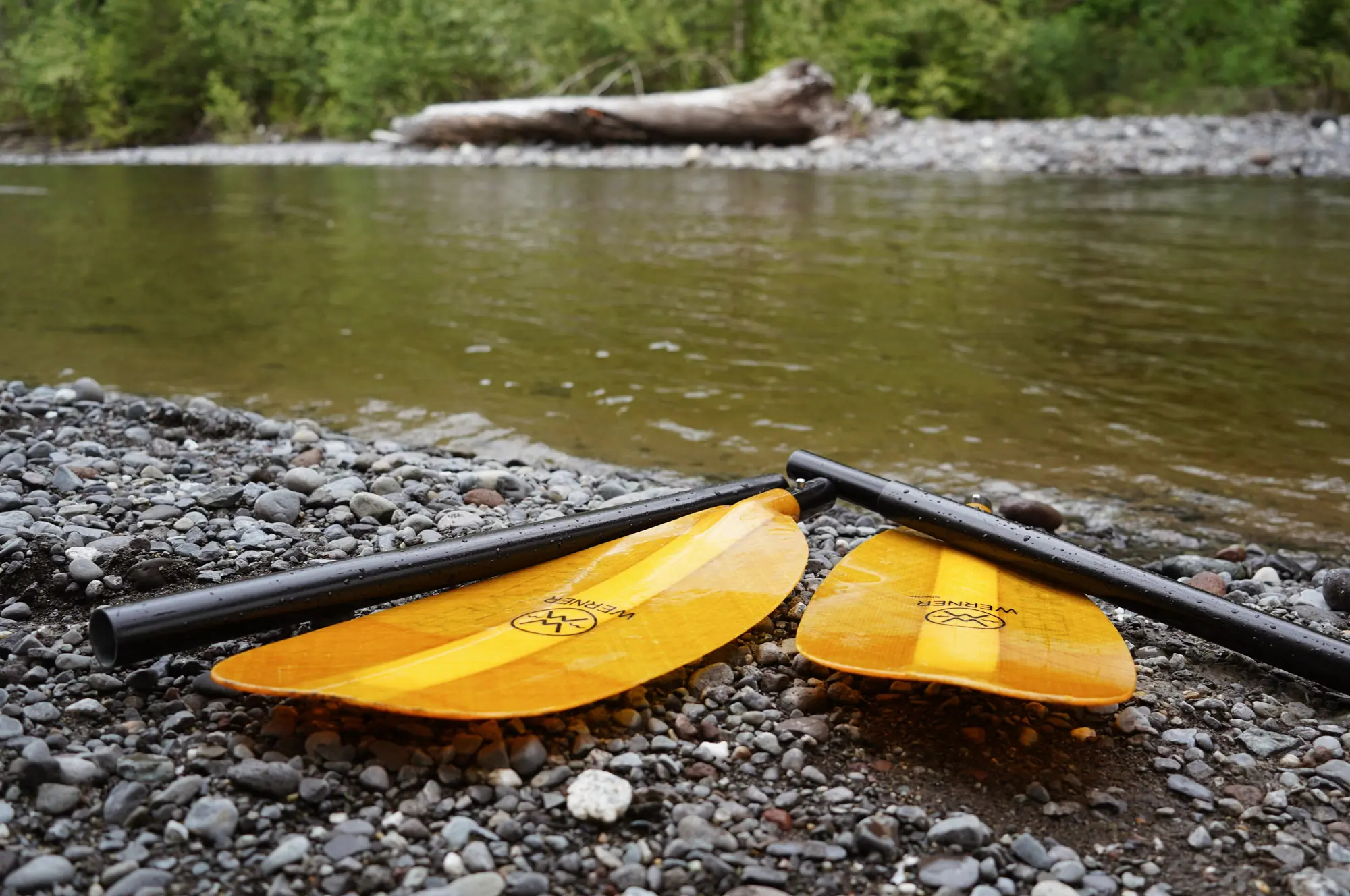The four-piece Sherpa paddle on the shore of a river