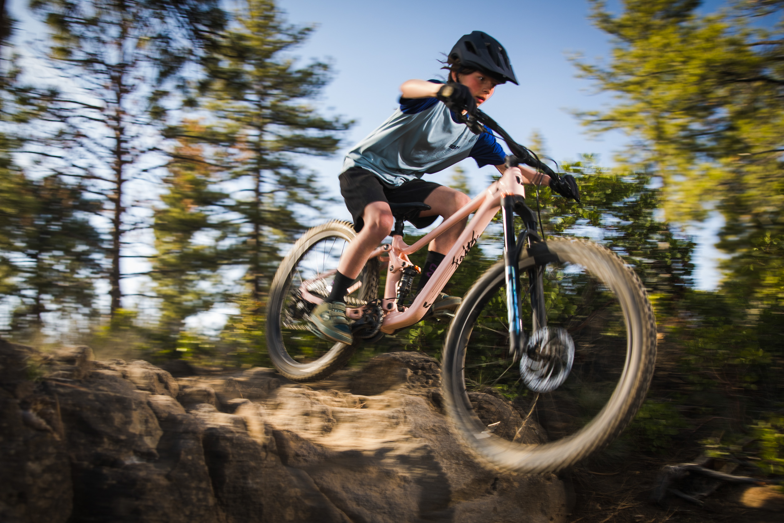 Young mountain biker hucking a drop on a Liv Faith