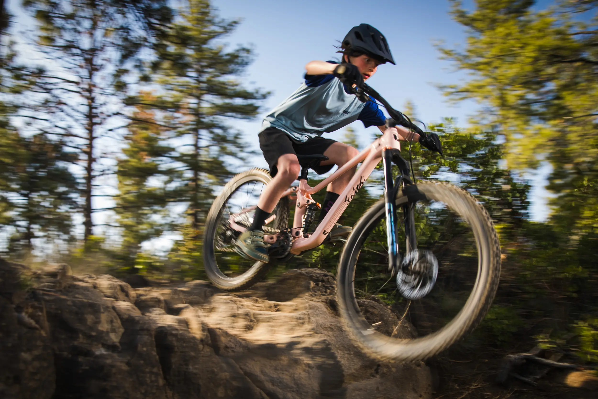 Young mountain biker hucking a drop on a Liv Faith