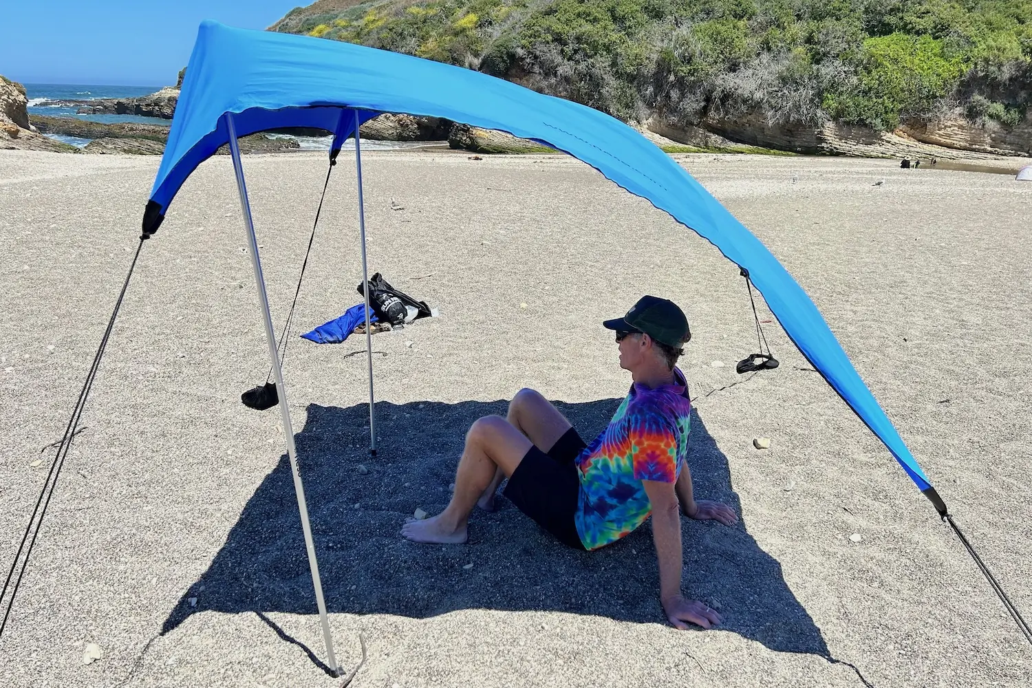 A man sitting in the shade under the Neso 1 beach tent