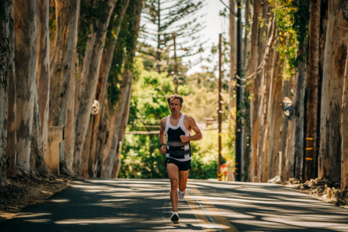 Man running down a tree lined street