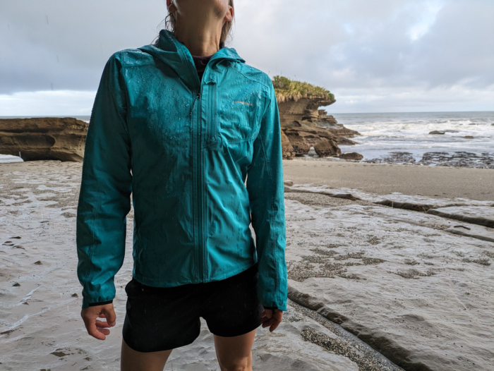 A hiker wearing the Storm Racer at the beach in New Zealand