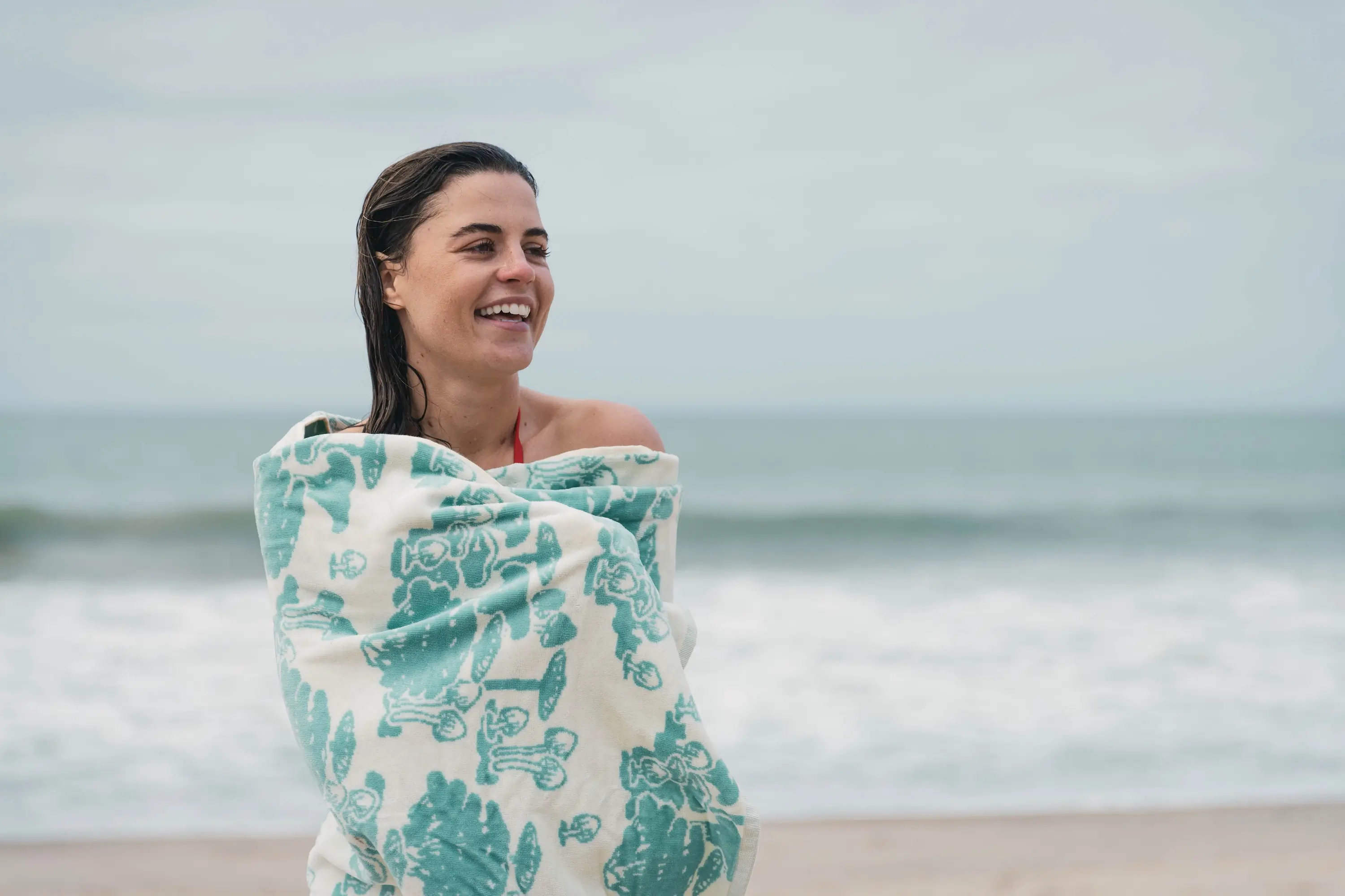 A woman drying of with a beach towel on a southern California beach