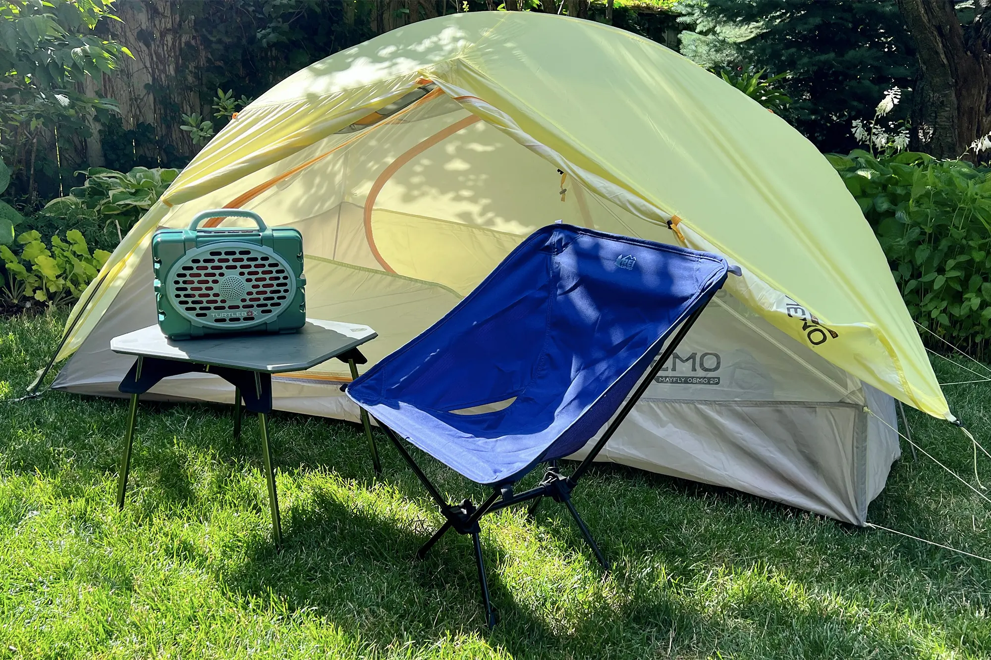 turtlebox gen 2 speaker on camping desk next to tent and camping chair