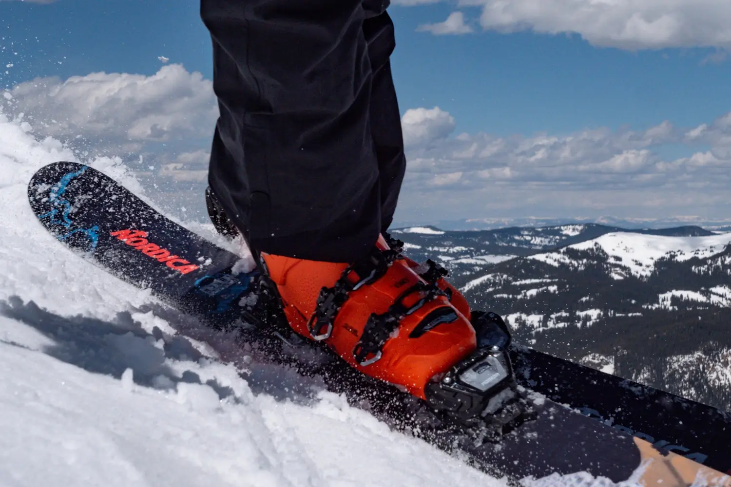 Skier wearing orange boots on Nordica skis