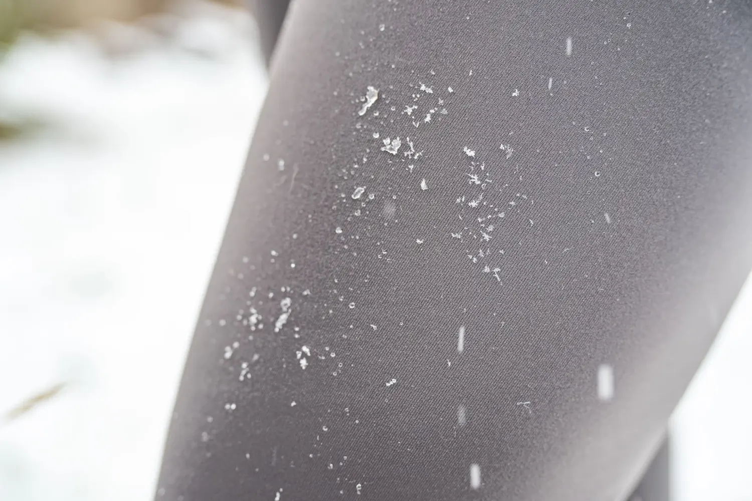 Close-up of defroster speed tights with snow falling on them