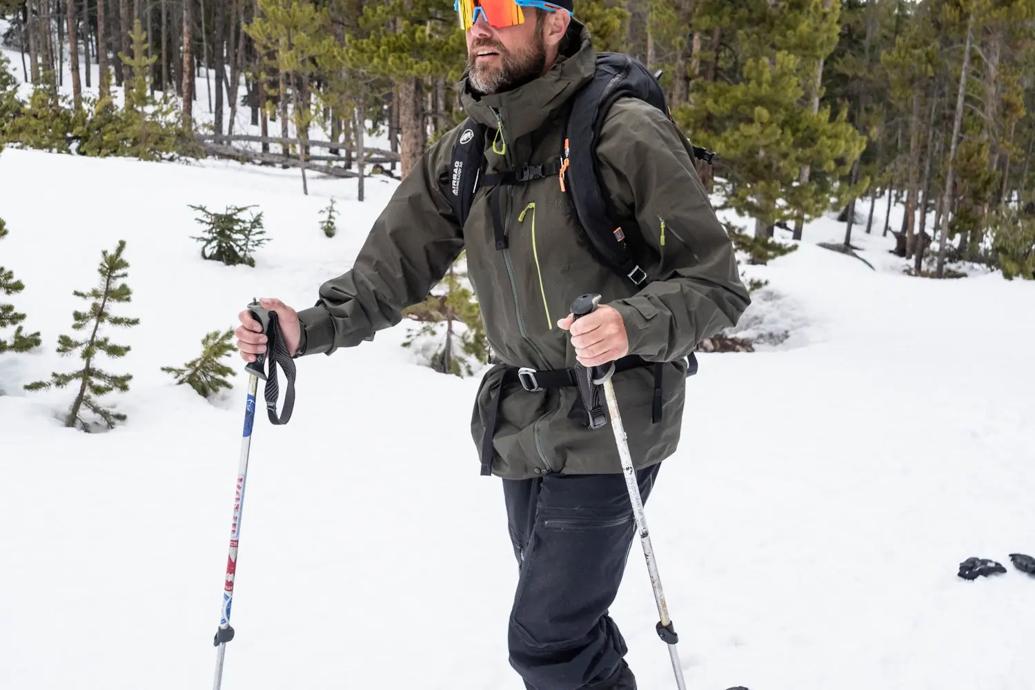 
Man trekking in snowy forest wearing a Rab Latok jacket
