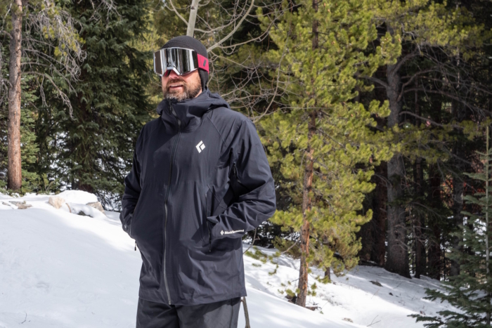 Man in a Black Diamond jacket and futuristic goggles standing in a snowy forest