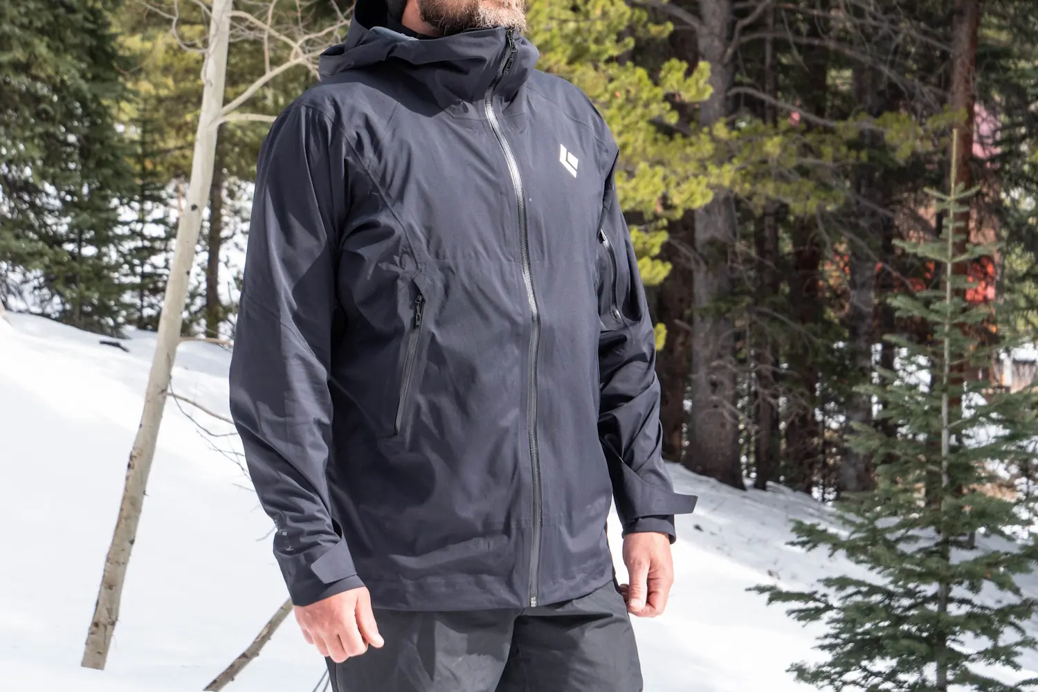 Man wearing Black diamond Men's Jacket in a snowy forest