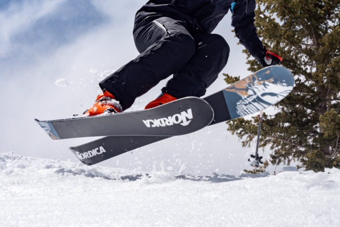 Skier jumping with Nordica Unleashed 114 skis on a snowy slope