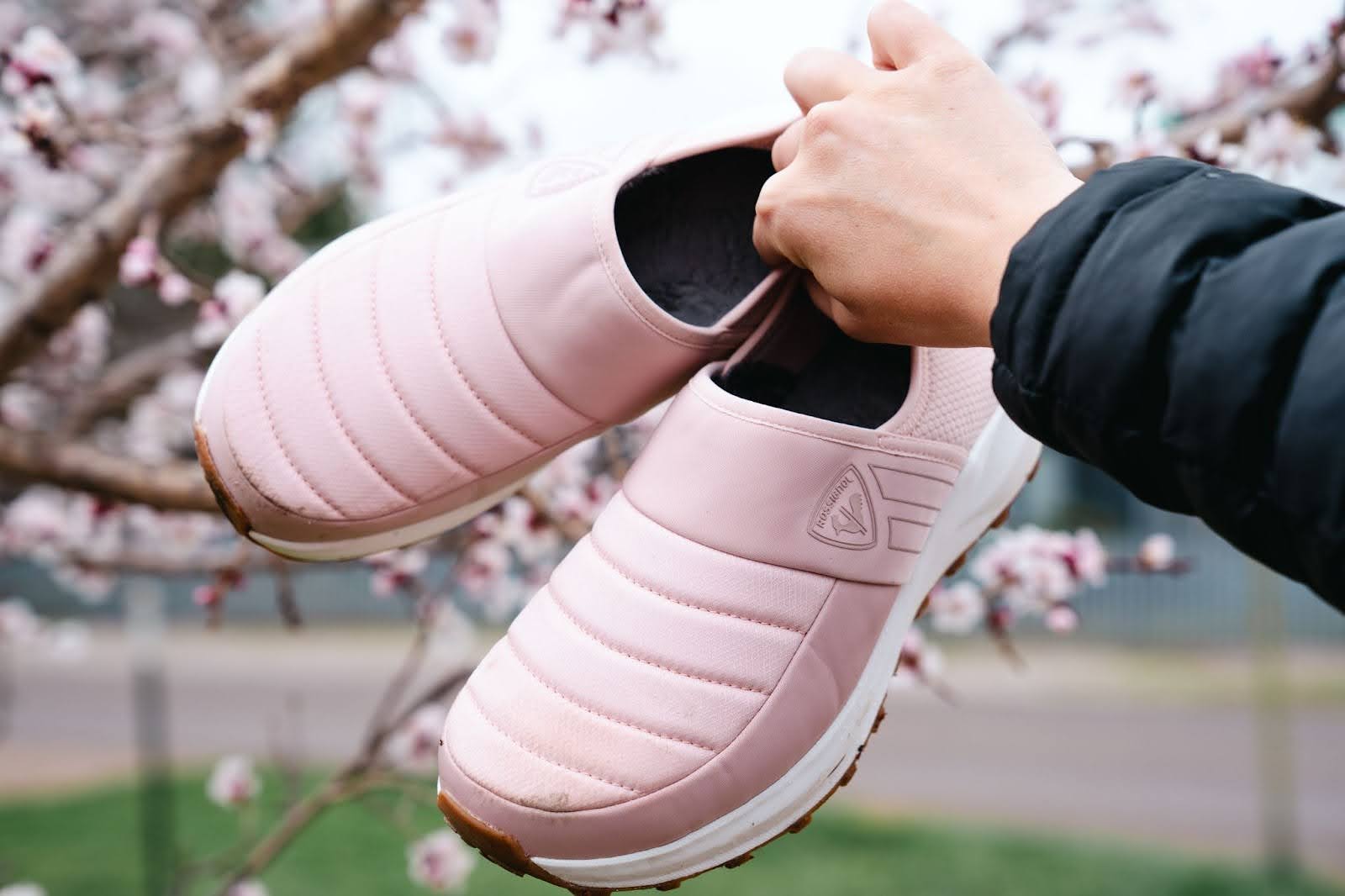 woman holding pair of pink rossignol chalet shoes