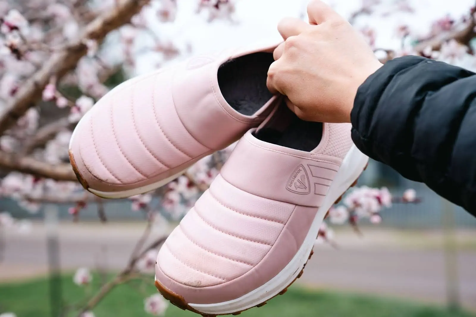 woman holding pair of pink rossignol chalet shoes