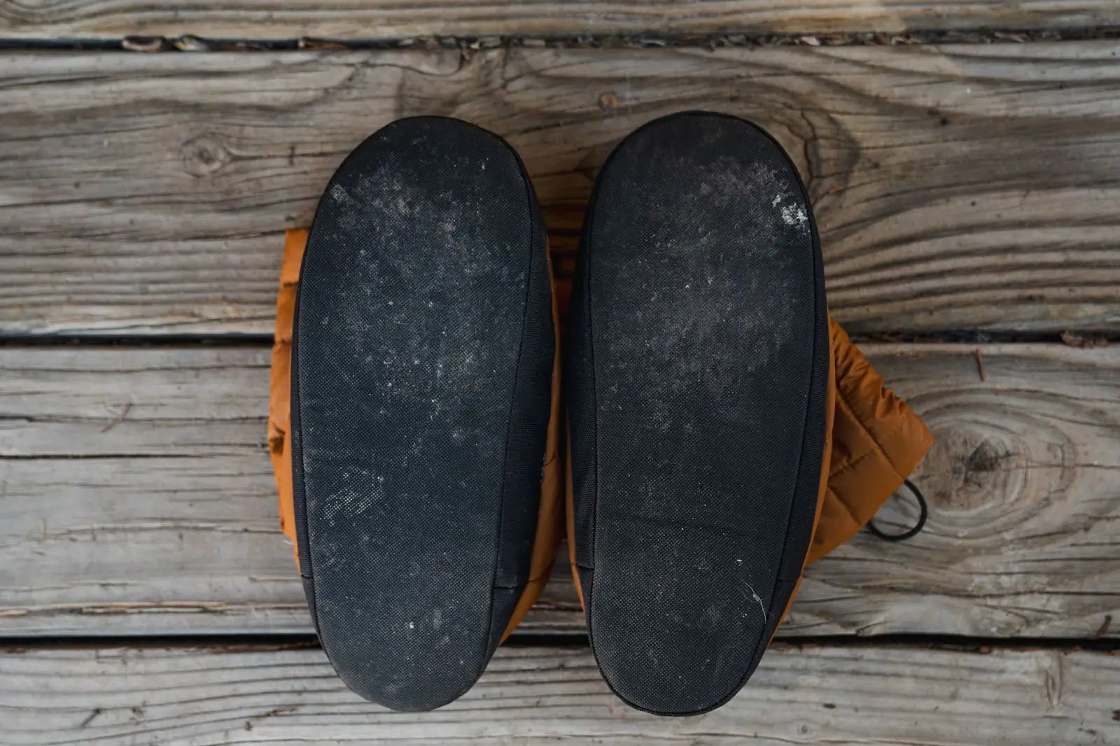 pair of sierra designs down booties with the soles facing the camera