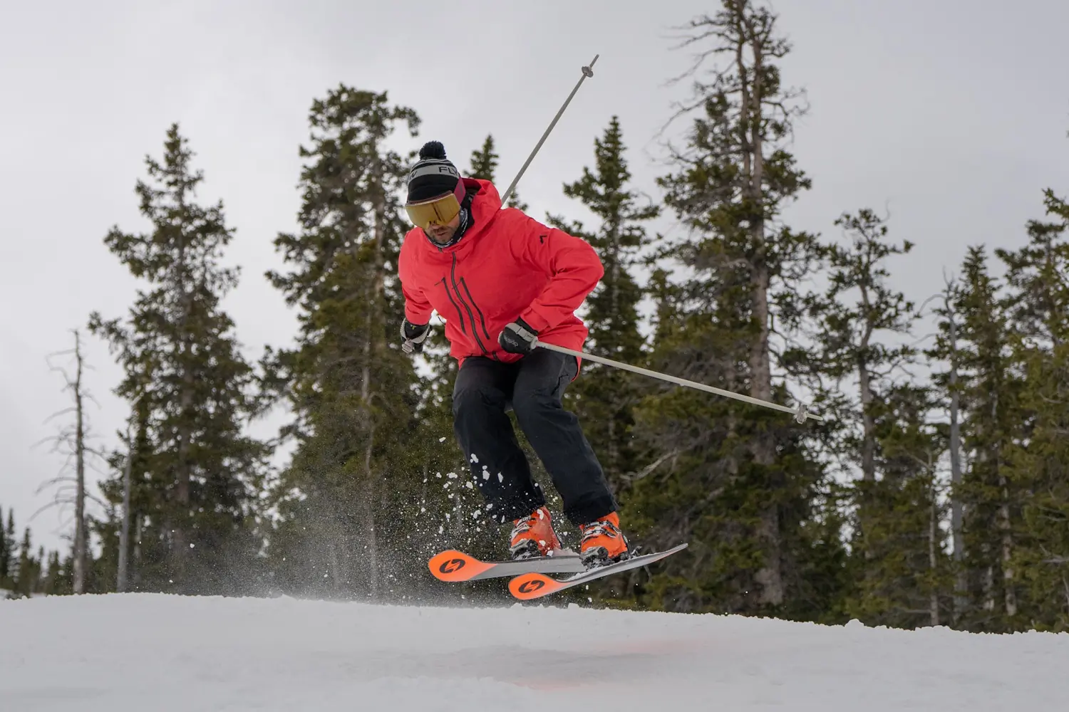 A skier performs a jump on a snowy slope, using Blizzard Anomaly 102 skis