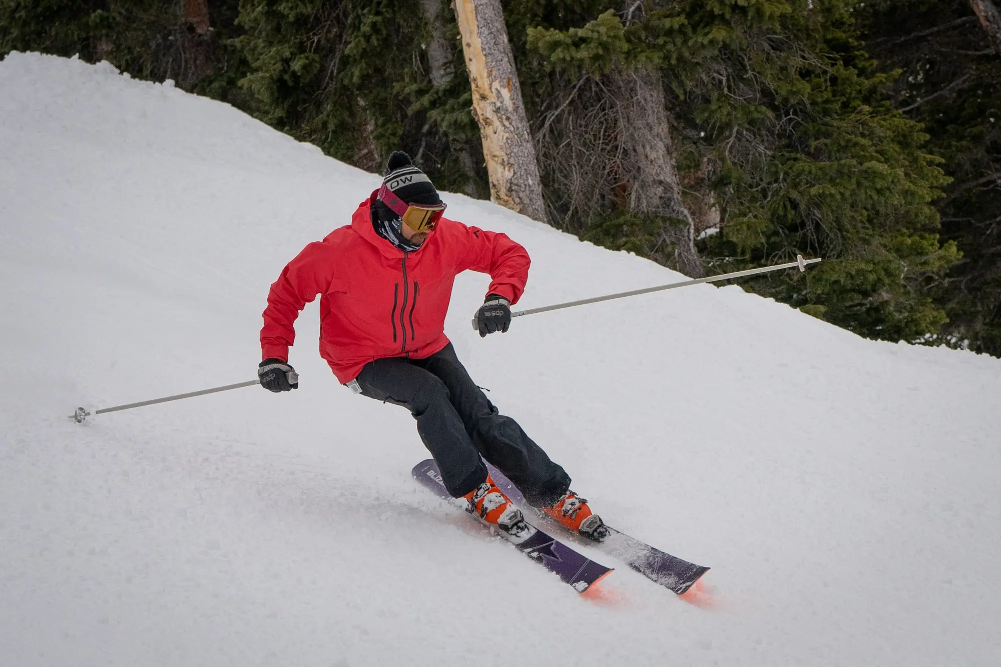 A skier makes a sharp turn on a snowy slope with Blizzard Anomaly 102 skis.