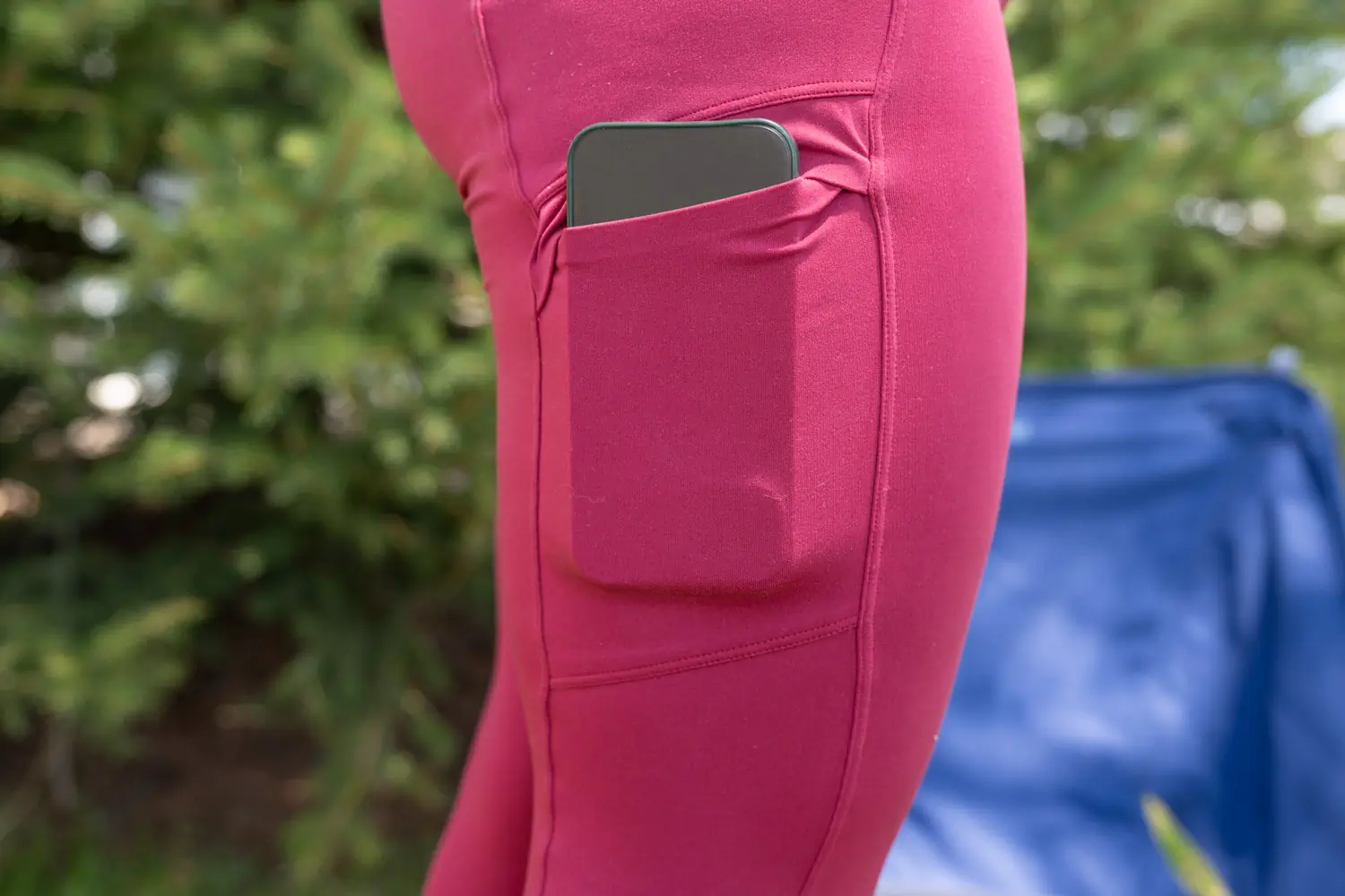 A person wearing pink leggings with a smartphone in the side pocket