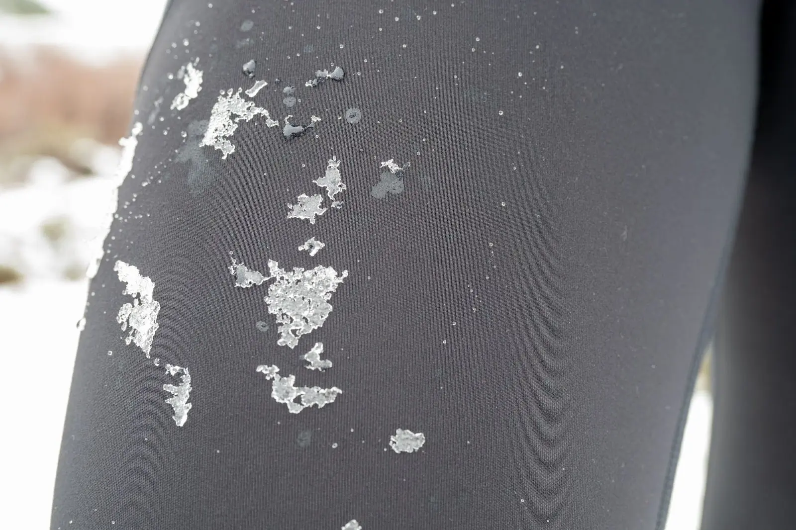 a close up of the north face winter warm pro tights with ice and water, showcasing their durability and moisture-wicking flashdry technology