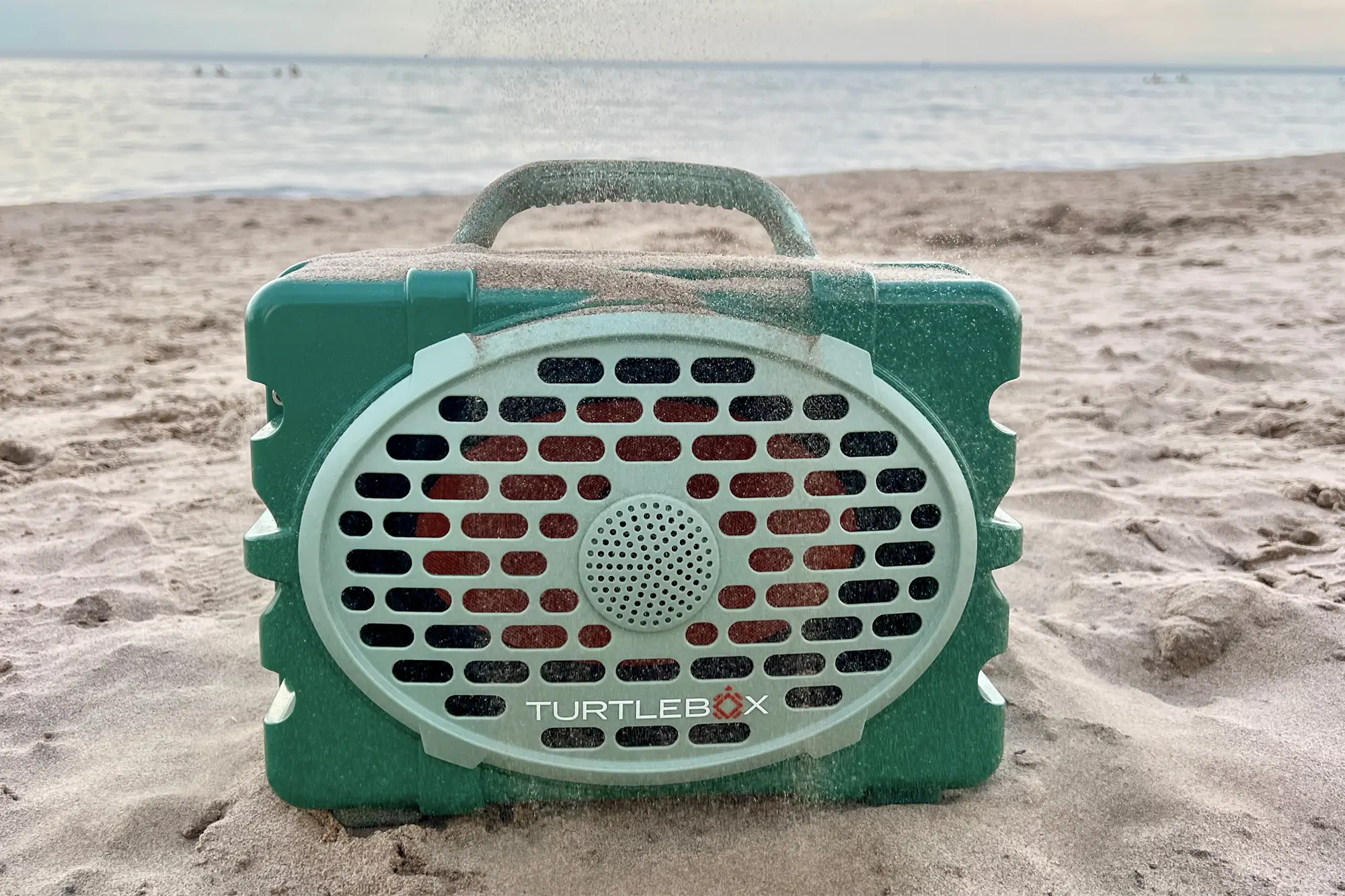 green utrtlebox gen2 speaker on the beach covered with sand