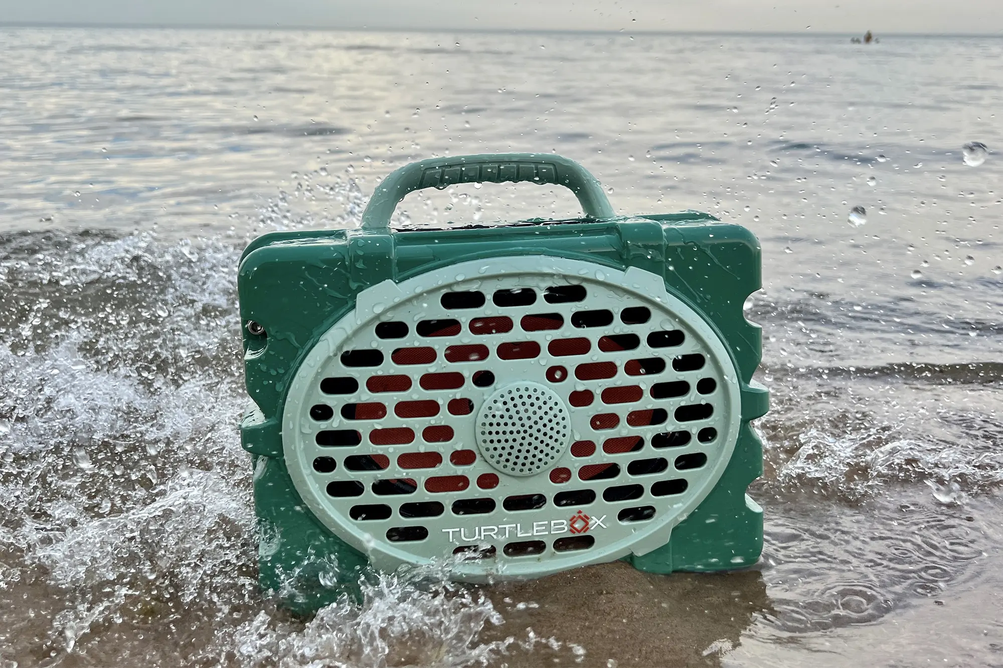 green waterproof turtlebox gen2 bluetooth speaker in shallow water
