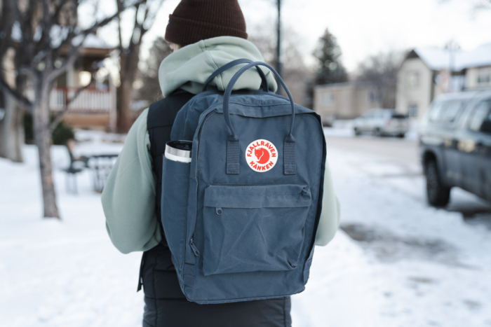 a woman wearing the fjallraven kanken on a snowy street in Colorado
