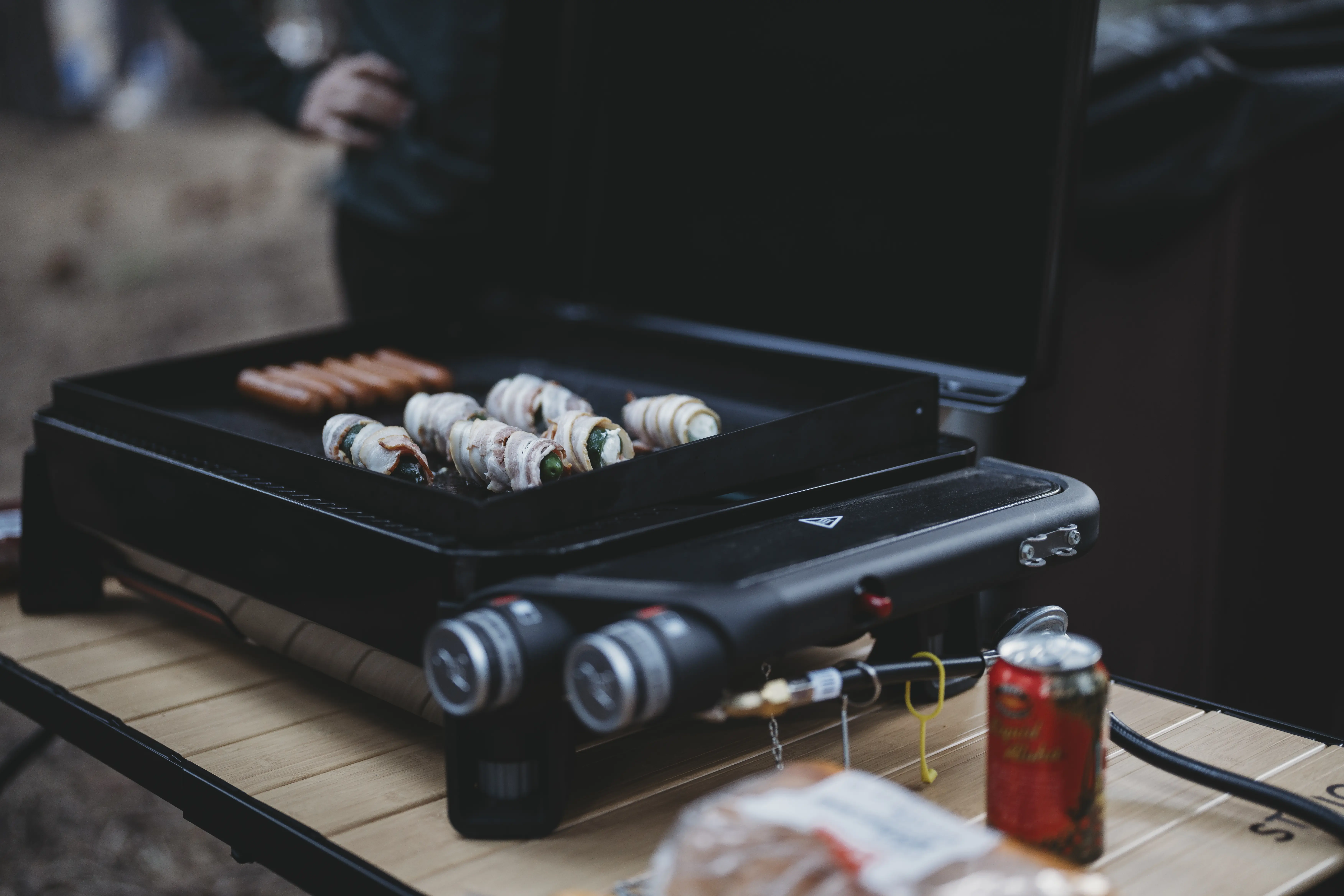 closeup view of the weber traveler griddle 22 cooking some sausages and peppers