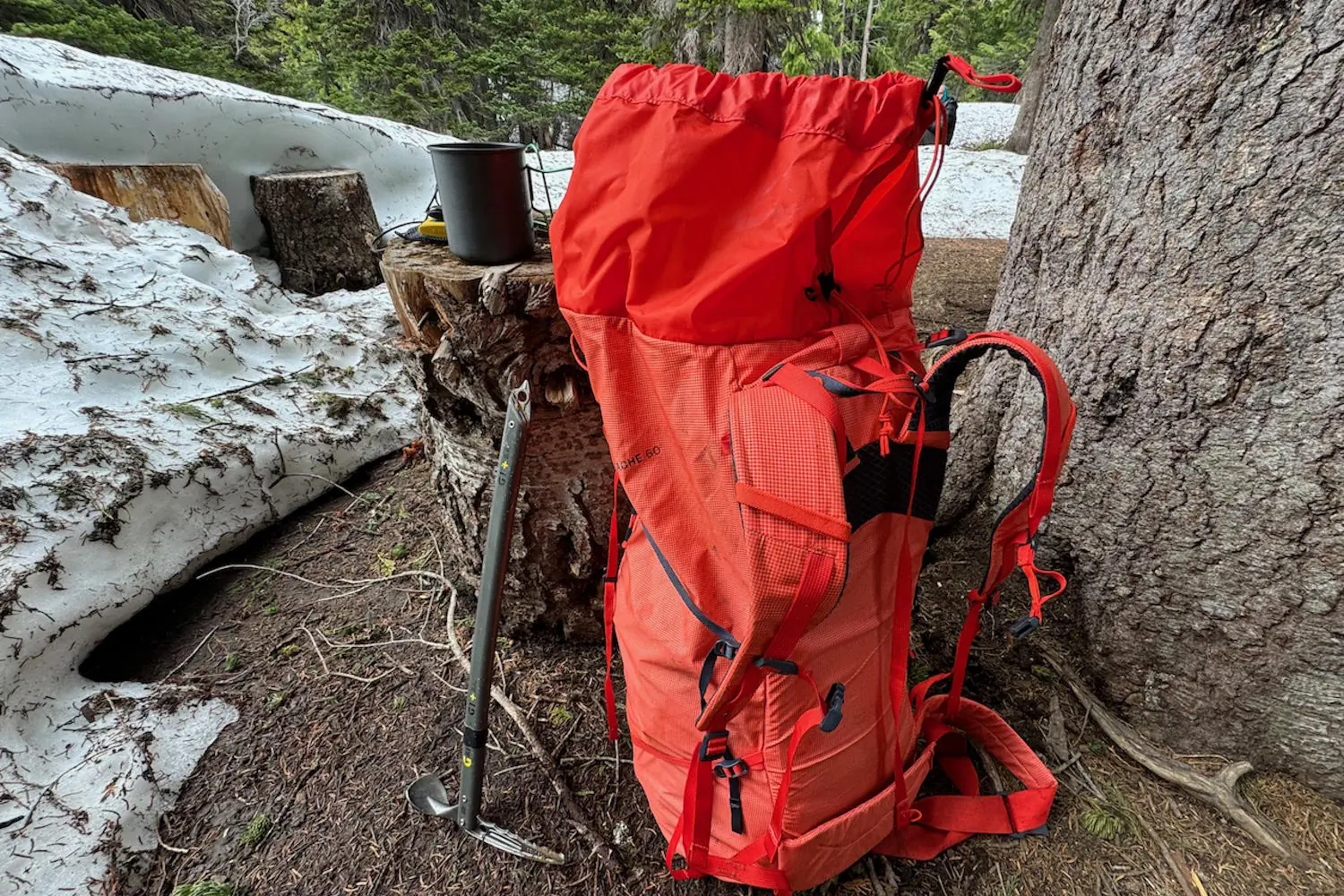 Backpack leaning against a tree, with an ice axe