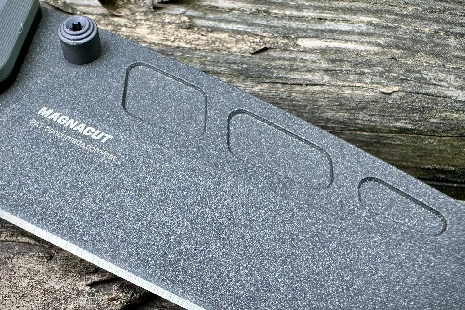 Close-up of a Benchmade knife featuring a Magnacut blade with pinch grip points
