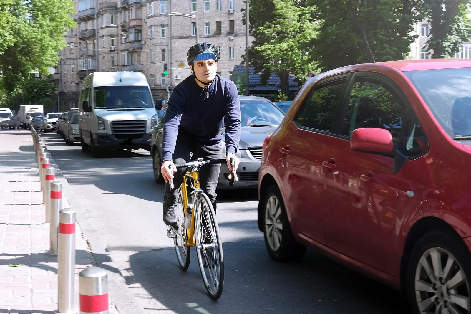 cyclist on a yellow bike rides on the road with cars, the theme of transport and active riding