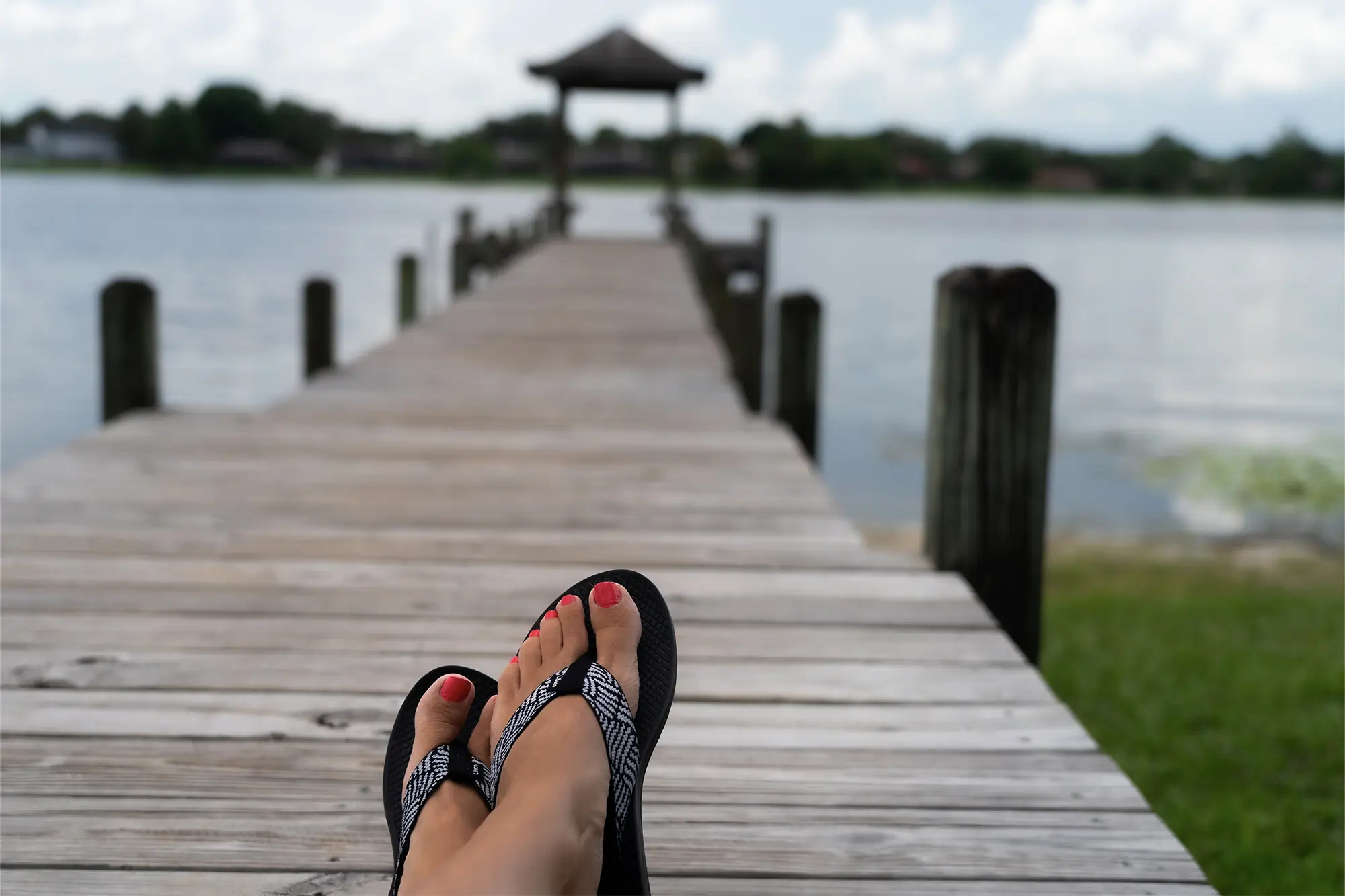 women feet in chaco classic flips on the dock