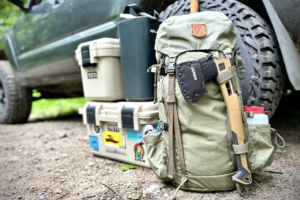 packed fjallraven kajka 35 pack next to a car, surrounded by essential outdoor gear ready for an adventure.