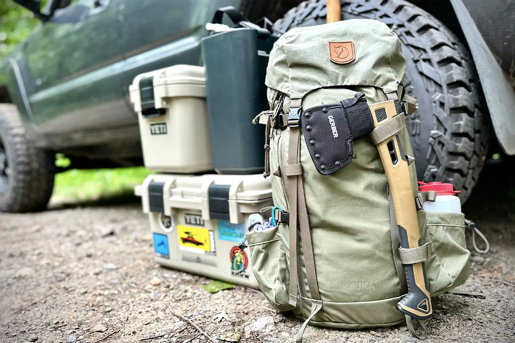 packed fjallraven kajka 35 pack next to a car, surrounded by essential outdoor gear ready for an adventure.