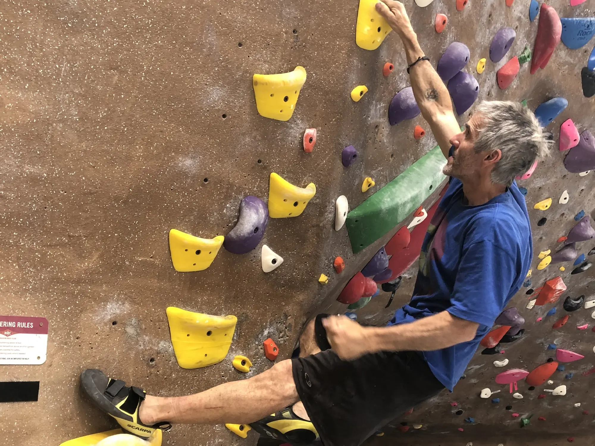 man warming up on jugs at the boulder rock club in scarpa arpia v shoes