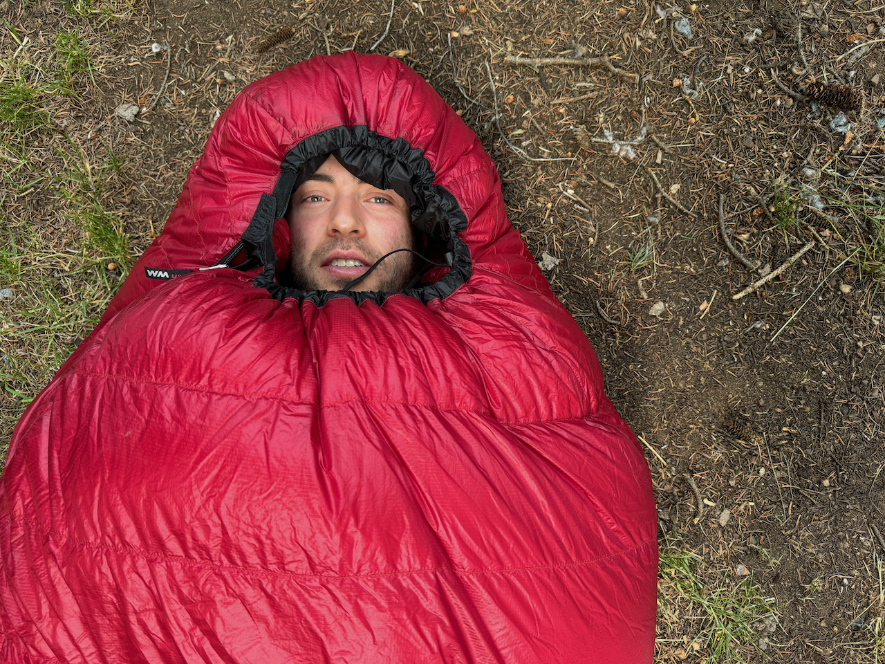 man inside red alpinlite sleeping bag