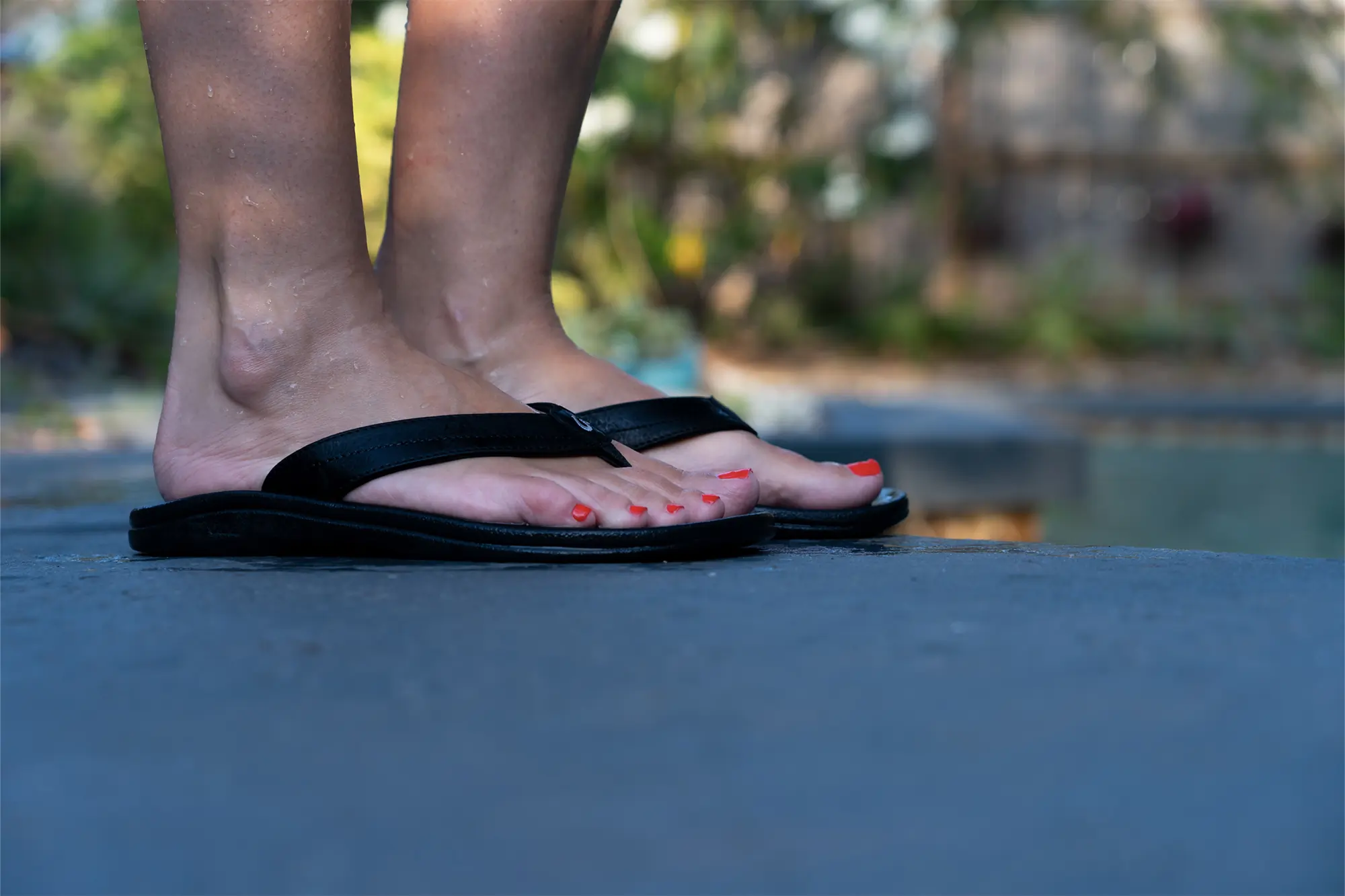olukai on feet by pool