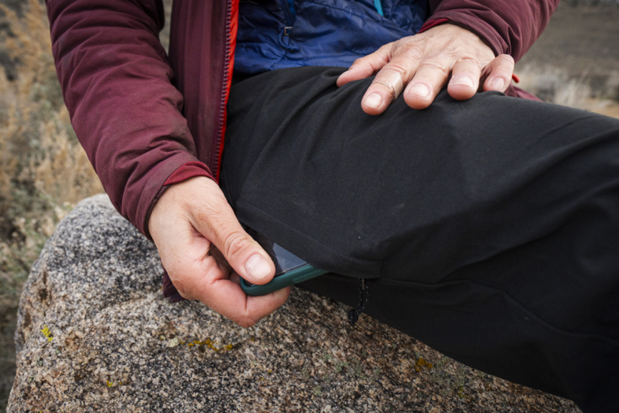 close up of woman placing phone inside patagonia quandary pant pocket